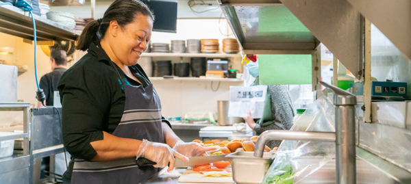 person slicing vegetables in a kitchen